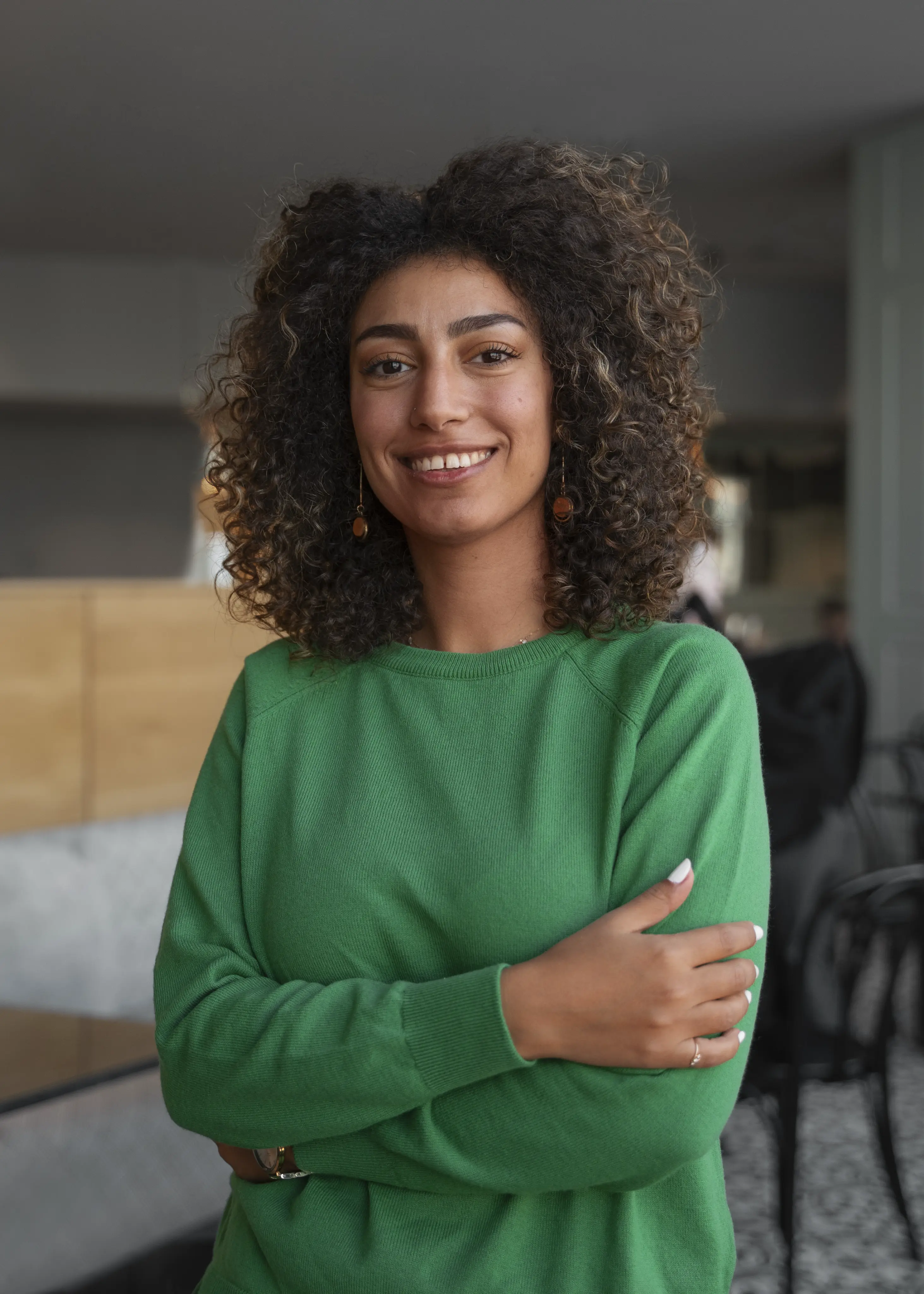 Paciente sorrindo, de braços cruzados, na Integral Clínica